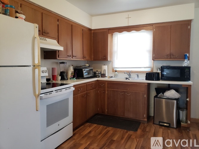 A kitchen with wooden cabinets and a white fridge.