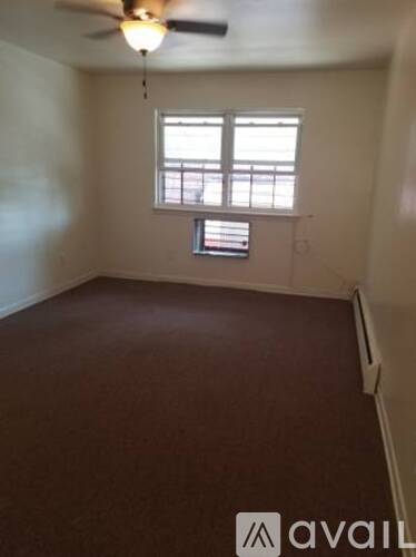 A room with a ceiling fan and a window with blinds.