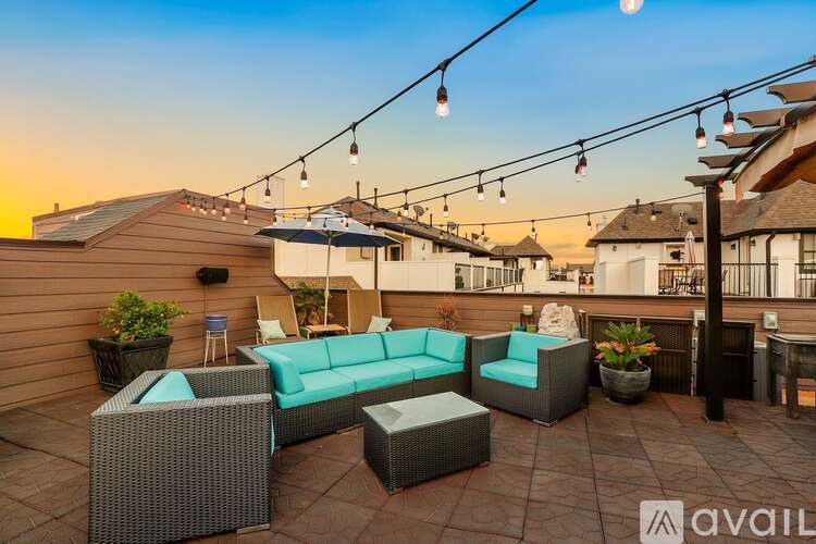 A patio with outdoor furniture and string lights.