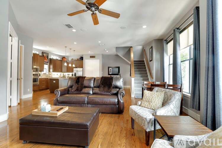 A living room with a brown leather couch and a coffee table.