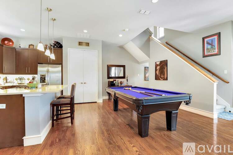 A room with a pool table and a bar.