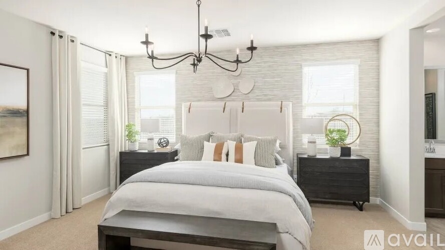 A bedroom with a large bed and a chandelier.