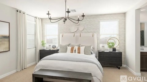 A bedroom with a large bed and a chandelier.