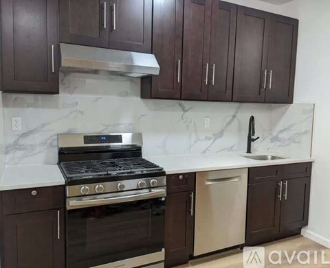 A kitchen with dark brown cabinets and a white marble countertop.