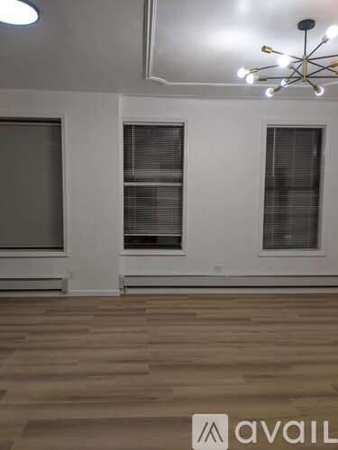 A room with wooden flooring and a chandelier.