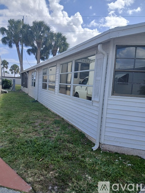 A white mobile home with a red walkway in front.