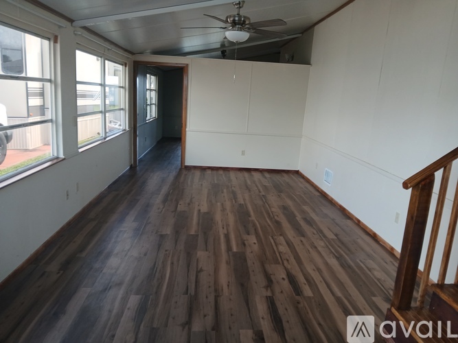 A room with wooden flooring and a ceiling fan.