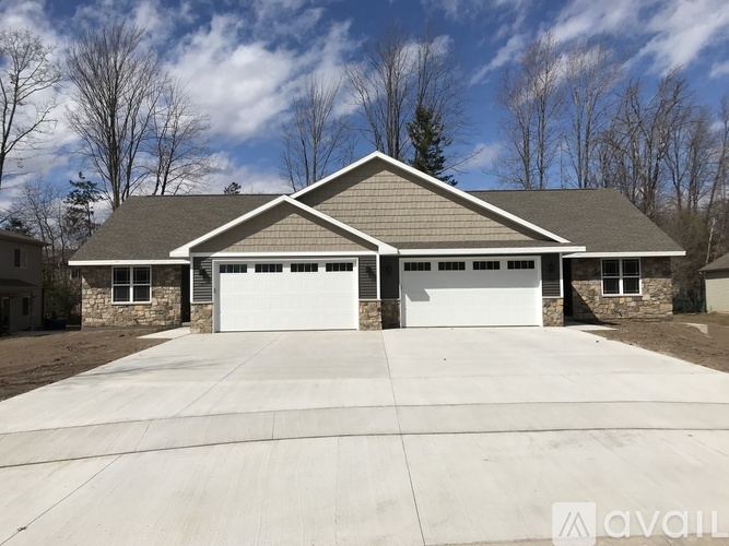 A house with a grey roof and two garages.