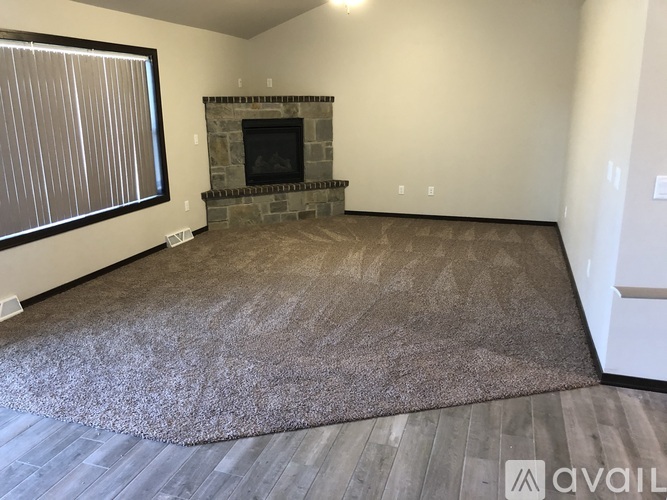 A living room with a fireplace and a rug.