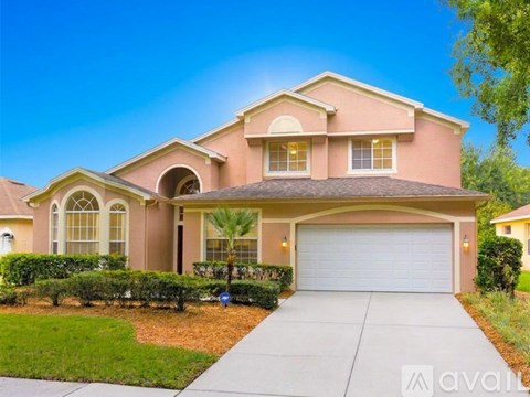 A large, two-story house with a garage and a driveway.