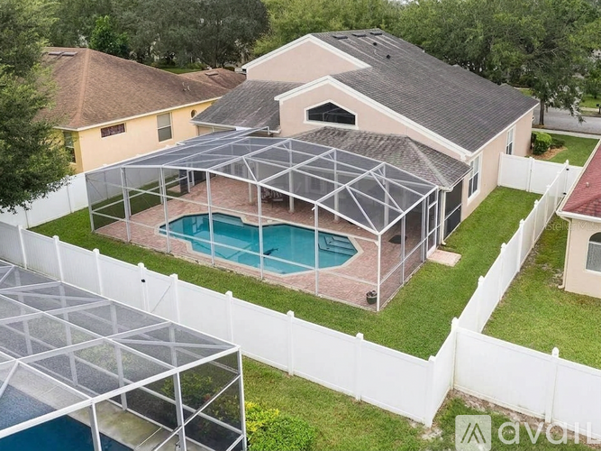 A house with a pool and a sunroom attached to it.