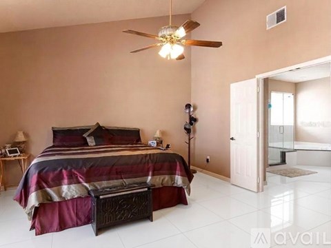 A bedroom with a bed, nightstand, and a ceiling fan.