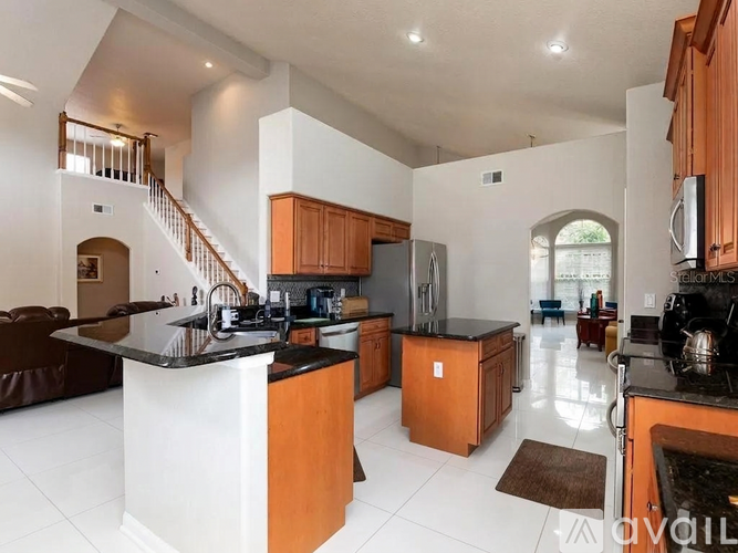 A modern kitchen with wooden cabinets and a black countertop.