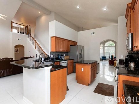 A modern kitchen with wooden cabinets and a black countertop.