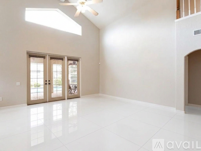 A spacious room with a ceiling fan and sliding glass doors.