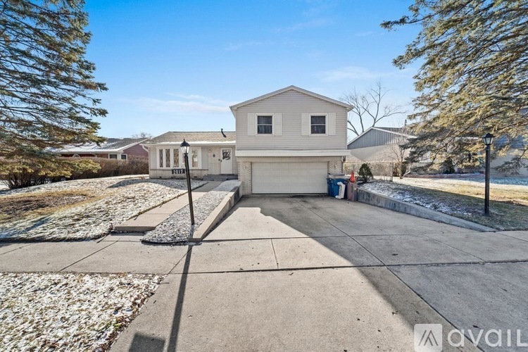 A house with a driveway and a garage is for sale.