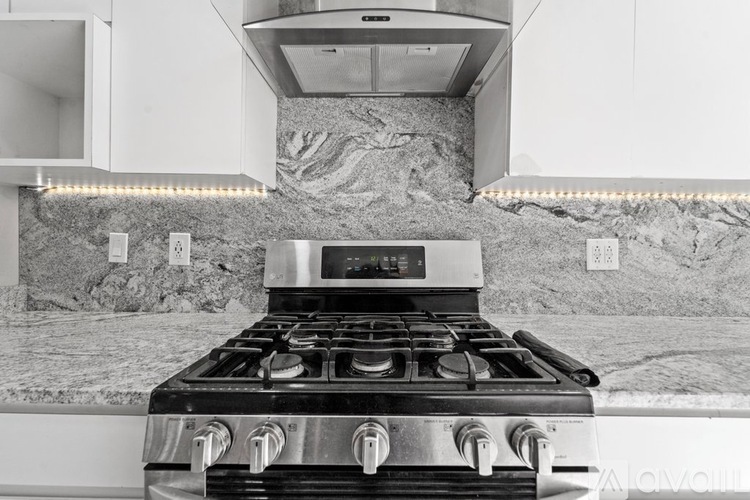 A modern kitchen with a stove top oven and a range hood.