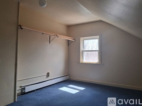 A room with a window and a blue carpet.