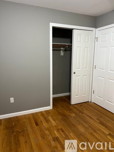 A room with a white door and a wooden floor.