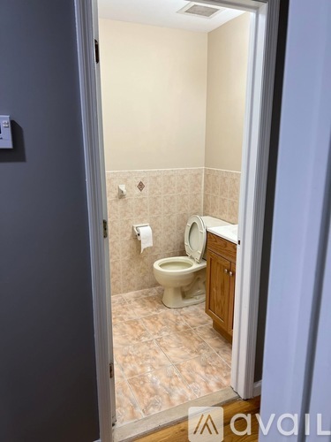 A bathroom with a toilet and a cabinet.