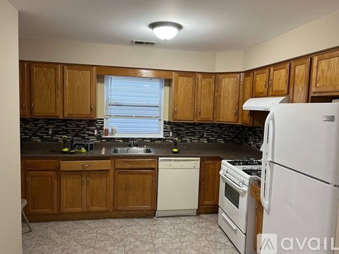 A kitchen with wooden cabinets and a white dishwasher.