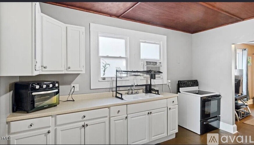 A kitchen with white cabinets and appliances.