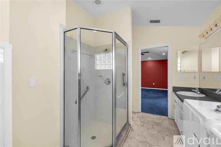 A bathroom with a glass shower stall and a red door.