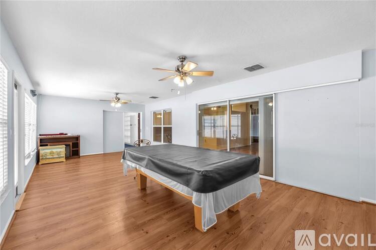 A bedroom with a bed, a ceiling fan, and a mirror.