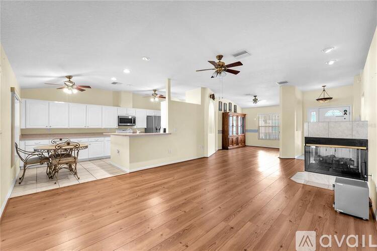 A spacious living room with a fireplace and a dining table.