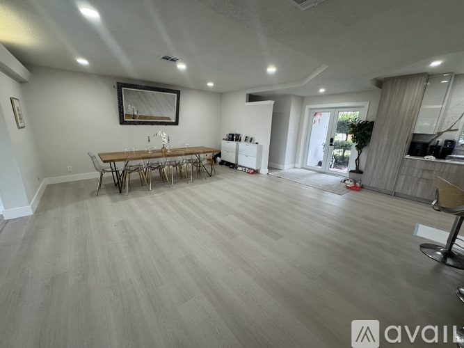 A spacious room with a dining table and chairs.
