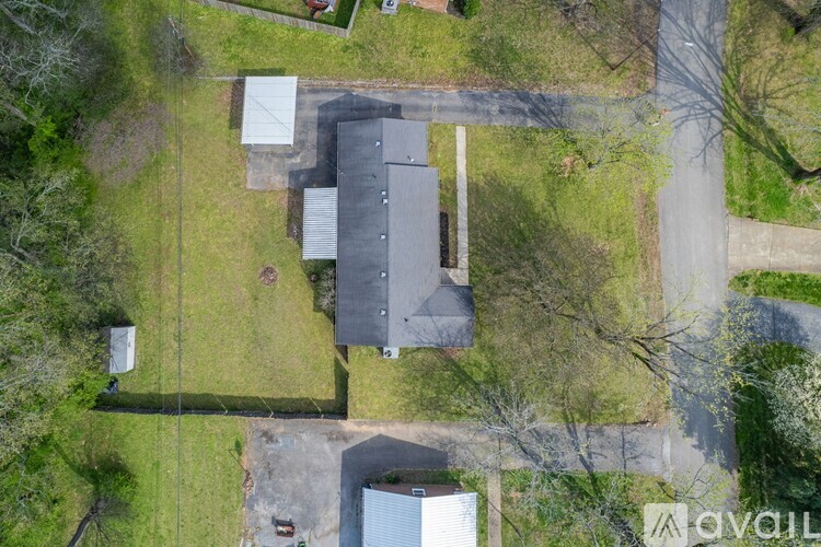 A bird's eye view of a property with a grey building and a white shed.
