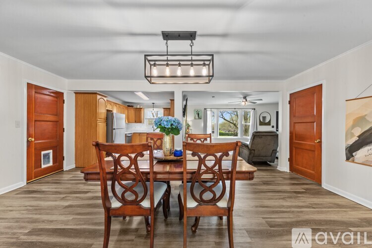 A dining room with a wooden table and chairs.
