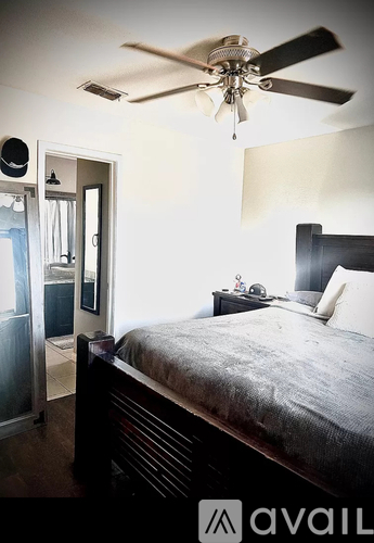 A bedroom with a bed, dresser, and mirror.