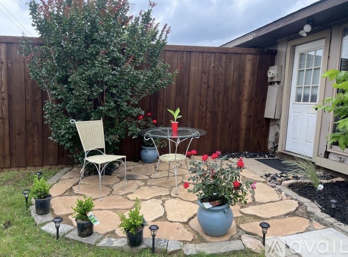 A backyard with a patio table and chairs.
