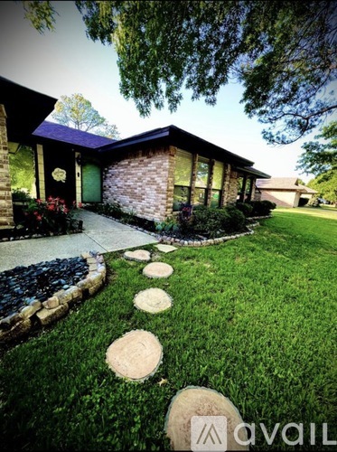 A house with a green door and a stone pathway leading to it.