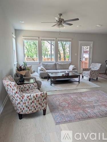 A living room with a patterned chair and a rug.