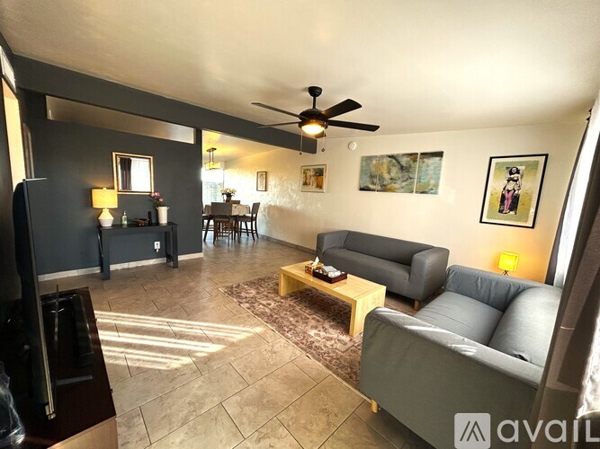 A living room with a grey couch and a wooden coffee table.