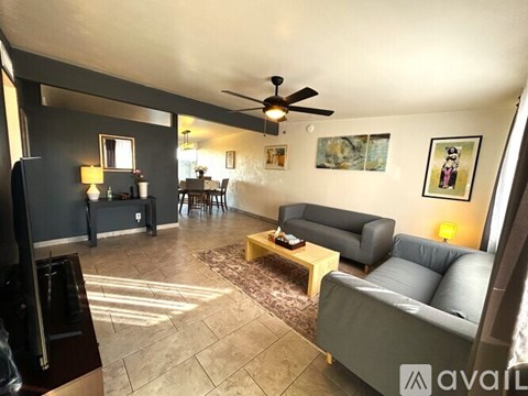 A living room with a grey couch and a wooden coffee table.