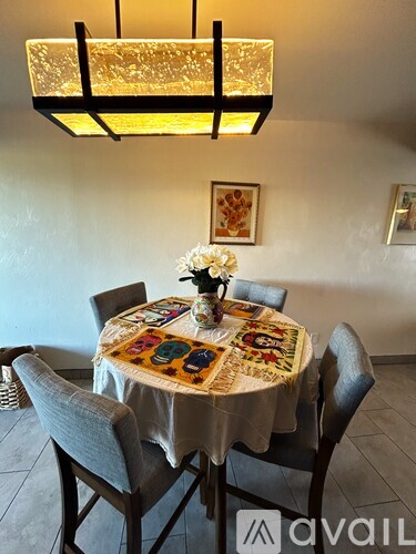 A dining room with a round table set for four.
