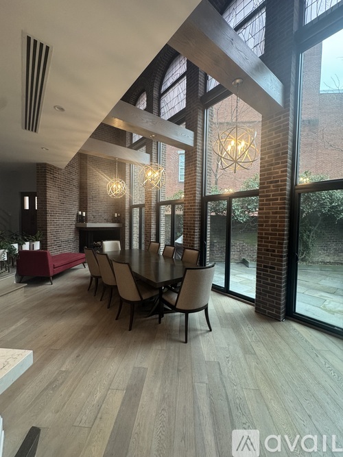 A modern dining room with a long table and chairs.