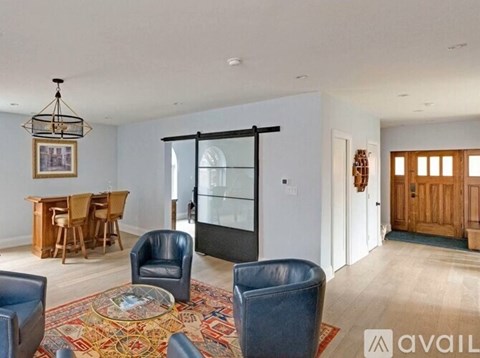 A living room with a rug and chairs.