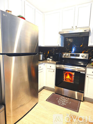 A modern kitchen with a stainless steel refrigerator and an oven with a glass door.