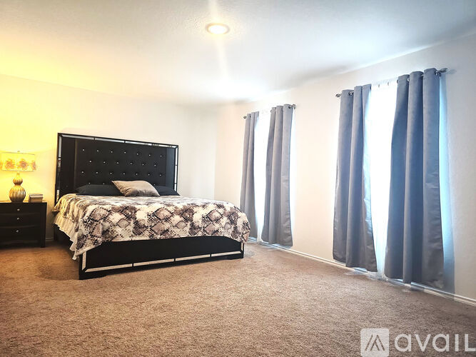 A bedroom with a large bed and a carpeted floor.