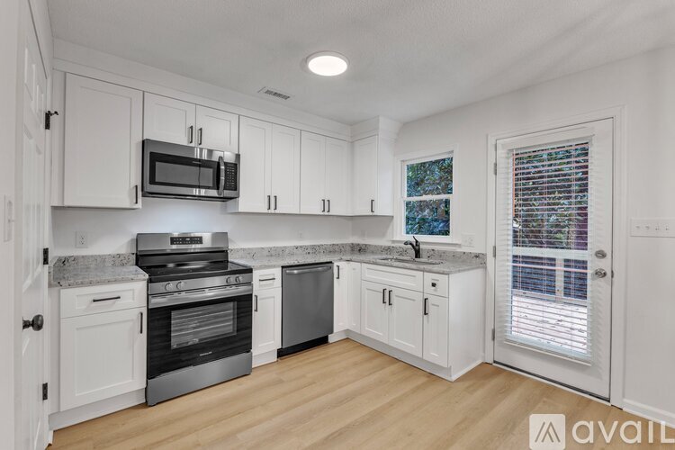 A kitchen with white cabinets and a granite countertop.