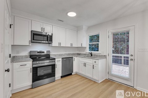 A kitchen with white cabinets and a granite countertop.