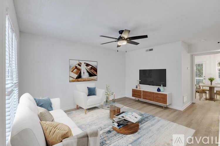 A living room with a white couch, a coffee table, and a ceiling fan.