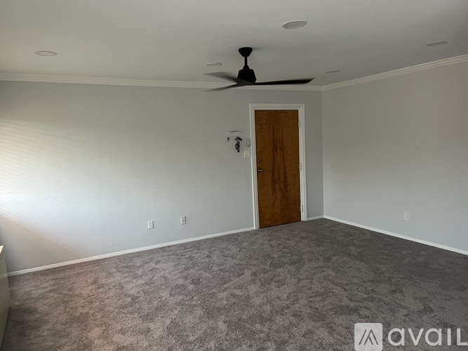 A room with a ceiling fan and a door.