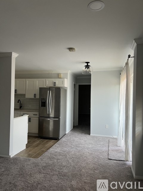 A kitchen with a refrigerator and cabinets.