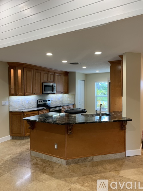 A kitchen with wooden cabinets and a granite countertop.