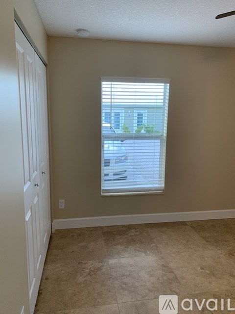 A room with a window and a view of a building outside.